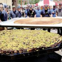 Volunteers place the top half of the bun on the cooked meat