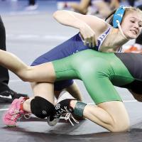 Remy Whitney reaches to grab the arm of Bishop McGuinness’ Nora Thompson during their match