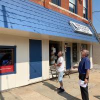 Gary Baumwart (right) and Rick Allen look over the facade of Baumwart’s building