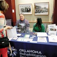 A woman talks with staff of the Oklahoma Department of Rehabilitation Services
