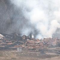 Family members take a break from sorting through rubble of the home