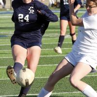 Payton Brickey kicks past a Bombers defender