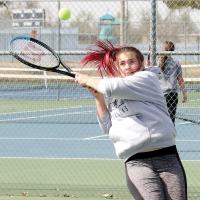 Allynda Idell follows through on a two-handed backhand return shot