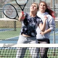 Melanna Idell steps in front of her sister Allynda to hit an overhand return