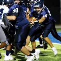 Deacon Tillery runs behind two linemen