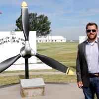 Adam Fox stands in front of the airport entrance