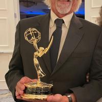 Art Peters holds up his Heartland Regional Emmy Award