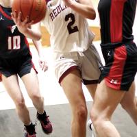 Ashlyn Evans-Thompson tries to lean around a defender for a shot attempt