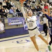 Nazhoni Sleeper eyes the basket as she jumps past Shawnee defenders to shoot a layup