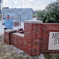 Brian Rukes stands in front of the four-panel plaza at Memorial Stadium