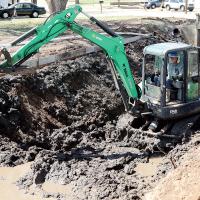A construction worker uses a backhoe