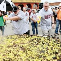 Volunteers squirt mustard over the pickles on the Big Burger