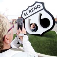 Two female riders take pictures of the Route 66 Monument 