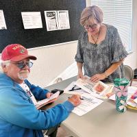 Carol Birchall helps a Blessing Baskets customer enroll