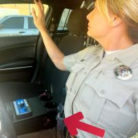 Renea Kendrick points to the video screen mounted inside a sheriff’s cruiser