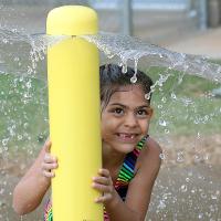 Brielle Fernandez hides under a wave of water