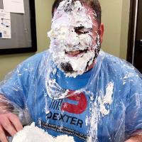 Bryan King grins after taking a pie to the face