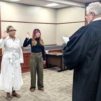 District Judge Bob Hughey swears in new CASA volunteers Jimiesha Longerbeam (left) and Leilani Labourdette