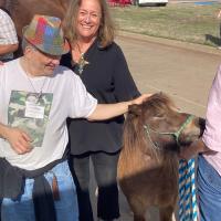 Anita LaCava Swift pets a horse with Milan, a resident at CFL