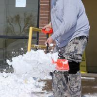 C.L. Harrell shovels snow outside United Supermarket