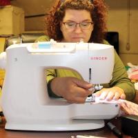 Richardson slips a lever on her sewing machine