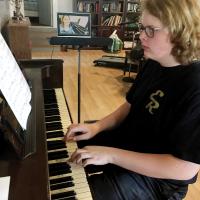 Caden Bayne practices on piano