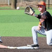 Kingston Arnold eyes a pickoff throw into his glove as an Okarche runner dives back into second base