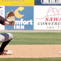 Kyler Thiessen eyes a pickoff throw to second base as an Elk City runner slides headfirst into the base