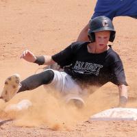 Talon Arnold slides into third base as a pickoff throw sails past
