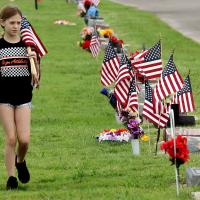 Lyzbeth Cox walks among the American flags placed on graves