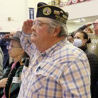 Charles Rukes (center) joins other veterans in saluting