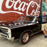 Clay Fees stands beside a 1967 Pontiac GTO