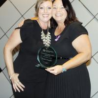 Karla Docter, left, presents the Compass Award to Kristie Chandler