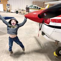 Cooper Higdon jumps into the air with joy while waiting to see inside one of the planes