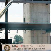 A construction worker uses a crane to work on a piece of steel