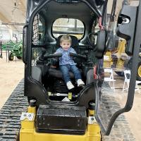 A future farmer plays with the controls on this piece of farm equipment