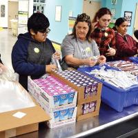 Volunteers assemble bags at Food Bank