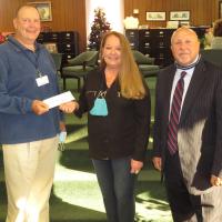 Debbie Harrison presents a donation to Matt Goucher as Craig McVay looks on