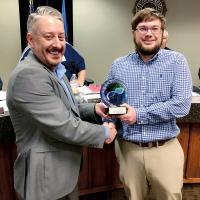 Chad Denson, left, presents Dustin Downey with an award