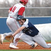 Palmer Ellis reaches around a base runner to try and knock down a wide throw