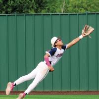 Kyson Jenkins leaps into the air to try and catch a fly ball