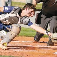 Gage Lesperance reaches out to try and tag a sliding Enid base runner at the plate