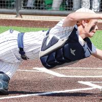 Austin Steffler stretches out to tag a Bishop McGuinness base runner for an out