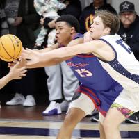 Gabe Osburn reaches around a Tulsa Memorial player to knock the ball away