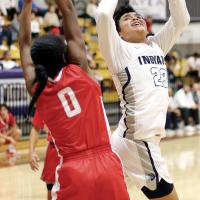  James Reveles twists his body backward to shoot a basket