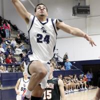 Tre Davis leaps through the air en route to one of his three slam dunks in the third period