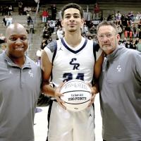 Tre Davis holds his 1,000-point ceremonial basketball