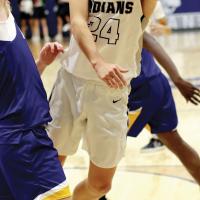 Alex Elizondo reaches around a defender to shoot an underhanded layup