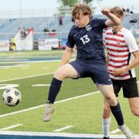 Luke Lemke leaps in front of a Carl Albert defender to clear the ball out of bounds
