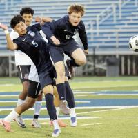 Luke Lemke uses his head to deflect a pass as teammate Carlos Garcia tries to avoid contact